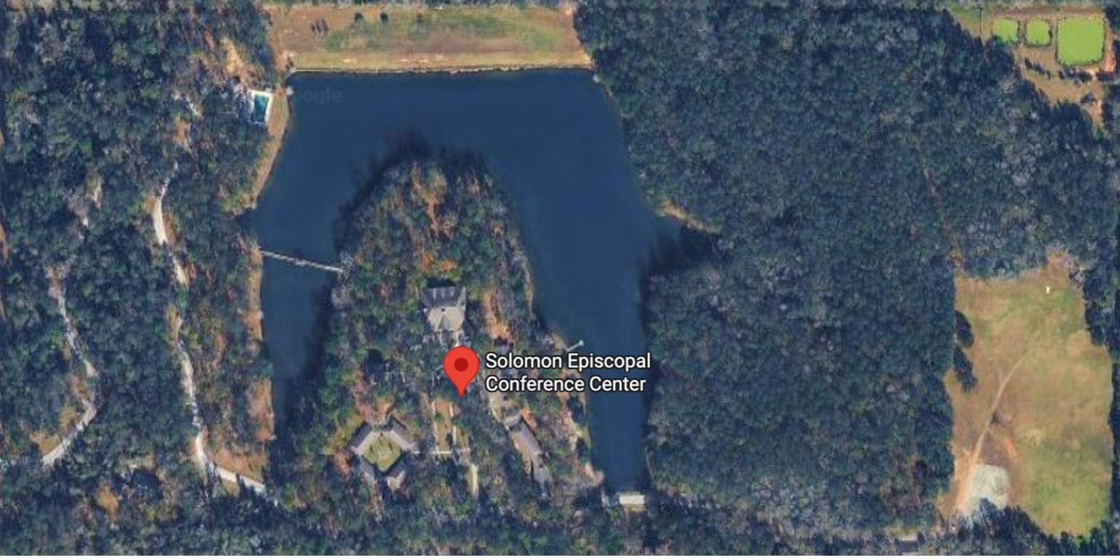 Aerial view of the Solomon Center campus on a 12-acre lake, surrounded by Louisiana pine forest